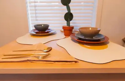 a table with plates and bowls and utensils on it at The Myrlande Dinvil Guest Suite in North Miami Beach