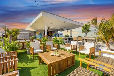 a patio with tables and chairs on a roof at Rooftop Pool Balcony Hollywood Beach Broad walk in Hollywood