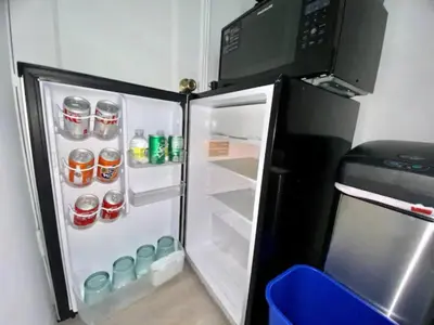 an open refrigerator with soda cans and a microwave at Private guest house in the heart of Miami! Surrounded by Miami's HOT spots! in Miami
