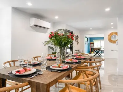 a dining room with a long wooden table with chairs at Villa Palma - Prime Location, Pool, Game Room, Outdoor Kitchen in Miami