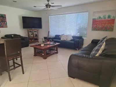 a living room with couches and a table at Pool House Resort heated swimming pool private duplex in Cutler Bay