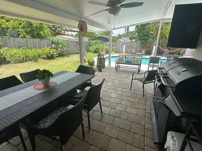 a patio with a table and chairs and a grill at Pool House Resort heated swimming pool private duplex in Cutler Bay