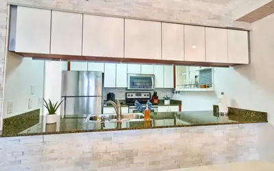 a kitchen with white cabinets and a sink at Serene View 1 BR in Miami