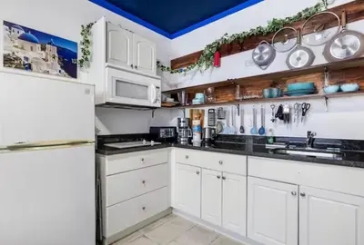 a kitchen with white cabinets and a refrigerator at The Plaza Miami Beach in Miami Beach