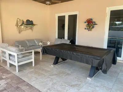 a living room with a ping pong table and a couch at Paradise Pool House in Dania in Dania Beach