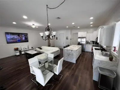 a large kitchen and living room with white furniture at Paradise Pool House in Dania in Dania Beach