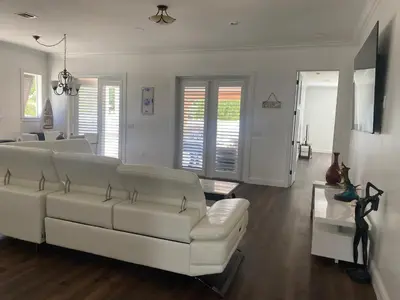 a living room with a white couch and a table at Paradise Pool House in Dania in Dania Beach
