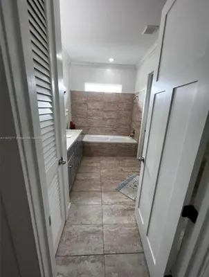 a bathroom with a shower and a tub and a toilet at Paradise Pool House in Dania in Dania Beach