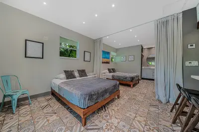 a bedroom with two beds and a table and chairs at New Villa Jungle Paradise Heated Pool BBQ Soccer in Miami