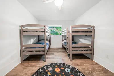 two bunk beds in a room with a rug at New Villa Jungle Paradise Heated Pool BBQ Soccer in Miami