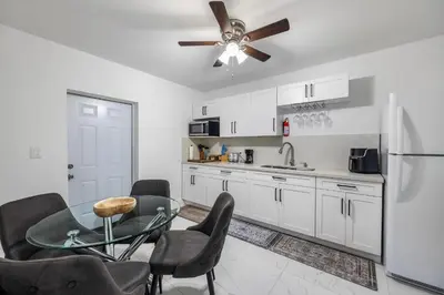 a kitchen with a table and chairs and a refrigerator at Cozy Apartment with a luxury King Bed in Miami Gardens