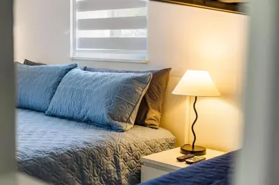 a bedroom with a bed and a lamp on a night stand at Cozy Apartment with a luxury King Bed in Miami Gardens
