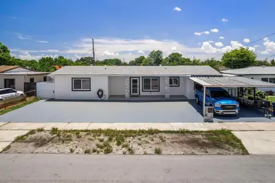 a house with a car parked in a driveway at Cozy Apartment with a luxury King Bed in Miami Gardens