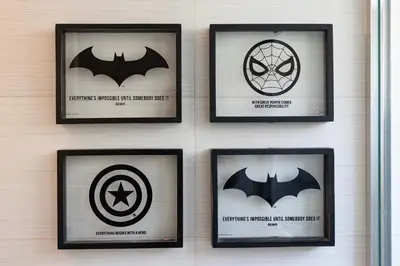 a wall with four framed pictures of batman at GroveO6 10 minutes from the Beach in Miami