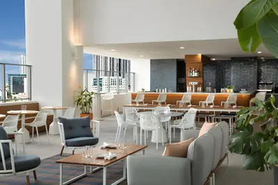 a restaurant with white chairs and tables and a bar at NEW Luxury Downtown Apartment - Gym Pool Workspace in Miami