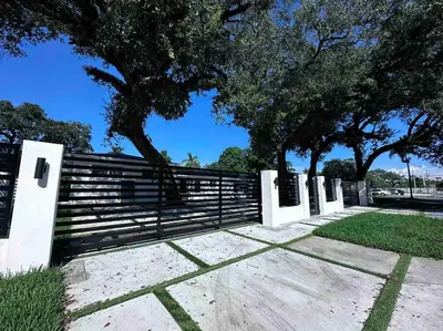 a fence in front of a park with trees at Villa Bethesda in Miami
