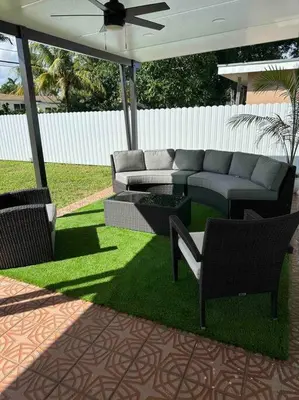 a patio with a couch and chairs on the grass at Villa Bethesda in Miami