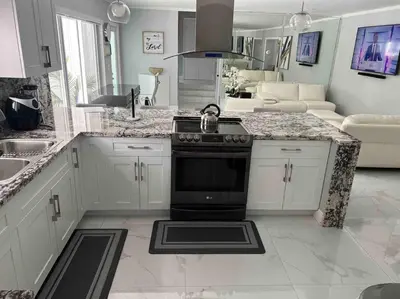 a kitchen with white cabinets and a black stove at Villa Bethesda in Miami