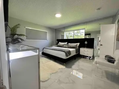 a large bedroom with a bed and a mirror at Villa Bethesda in Miami