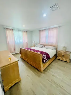 a bedroom with a large bed and two tables at Bright & Cozy Family Home Near Dania Beach in Dania Beach