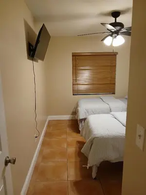 a room with two beds and a ceiling fan at Beautiful Miami Home in Miami
