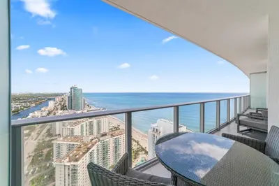 a balcony with a table and chairs and the ocean at Oceanfront Luxury Condo With WaterView in Hollywood