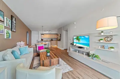 a living room with a white couch and a tv at Oceanfront Luxury Condo With WaterView in Hollywood