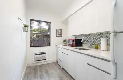a white kitchen with a sink and a window at B02 5 min from beach studio Midtown Wynwood in Miami