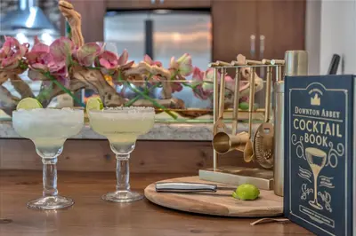 two glasses of margaritas on a table with a book at Family Beach Home With Home Theater & Heated Pool! in Hollywood