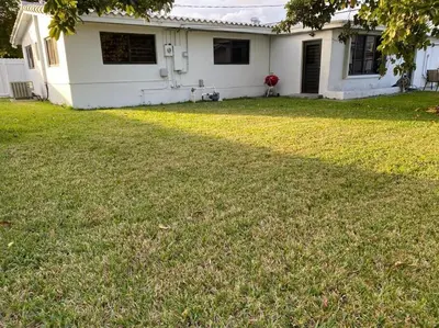 a white house with a yard with a yard at Luxurious Westchester Home Near Miami Clinics in Miami