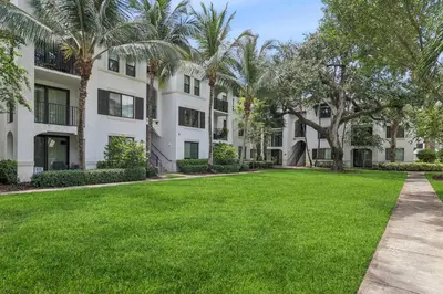 a large yard in front of a building with palm trees at Kasa Hollywood Fort Lauderdale in Dania Beach