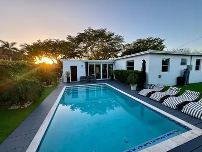a swimming pool in front of a house at Pura Vida Villa in Miami