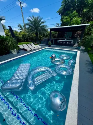 a swimming pool with two rubber ducks in the water at Pura Vida Villa in Miami