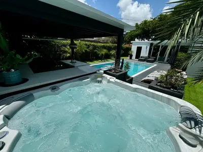 a hot tub in a backyard next to a swimming pool at Pura Vida Villa in Miami