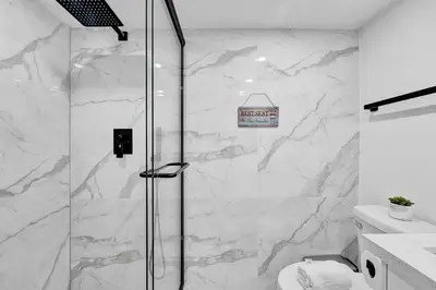 a shower in a bathroom with white marble walls at Cozy Oceanfront Beach Service 917 in Miami Beach