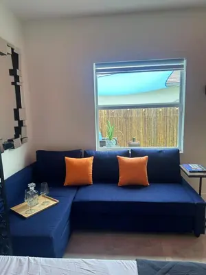 a blue couch with orange pillows in a living room at Tropical Studio in Miami