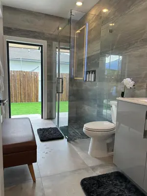 a bathroom with a toilet and a glass shower at Tropical Studio in Miami