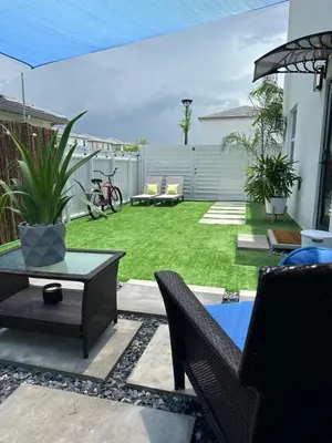 a backyard with a lawn with a table and chairs at Tropical Studio in Miami