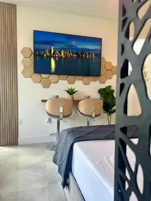 a bedroom with a bed and a television on a wall at Tropical Studio in Miami