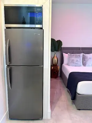 a kitchen with a refrigerator next to a bed at Tropical Studio in Miami