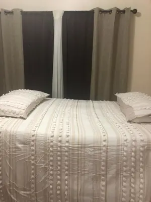 a white comforter on a bed with a window at Josiane Peace of stay in Miami