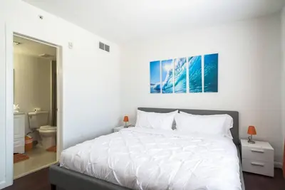 a bedroom with a white bed and a bathroom at 1Bedroom Collins 2 Blocks to Ocean with Paid Street Parking in Miami Beach