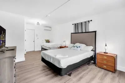 a bedroom with a bed and a dresser and a television at Spacious 5 Bedroom Heated Pool and Hot Tub, 12 minutes to the Beach in Hollywood