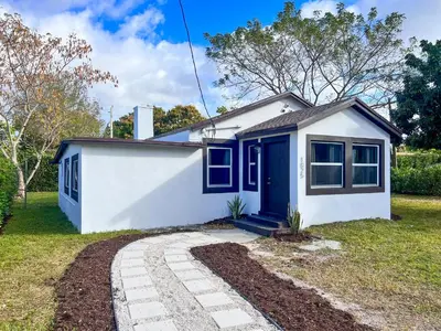 a small white house with a blue door at New 3Bedroom 2Bathroom Private Home in Miami