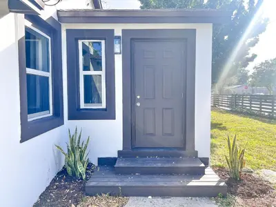 a blue door on a white house with stairs at New 3Bedroom 2Bathroom Private Home in Miami