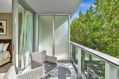 a balcony with two chairs and a bed on a balcony at Double Queen Room-Hosted by Sweetstay in Miami Beach