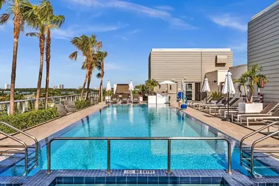 a swimming pool with palm trees and a building at Double Queen Room-Hosted by Sweetstay in Miami Beach