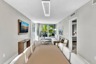 a living room with a long table and white chairs at King Suite balcony water views-Hosted by Sweetstay in Miami Beach