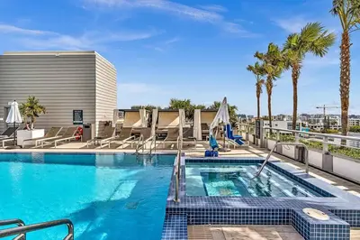 a swimming pool with palm trees and a building at King Suite balcony water views-Hosted by Sweetstay in Miami Beach