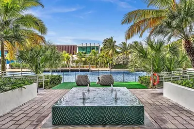 a fountain in the middle of a courtyard with palm trees at King Suite balcony water views-Hosted by Sweetstay in Miami Beach